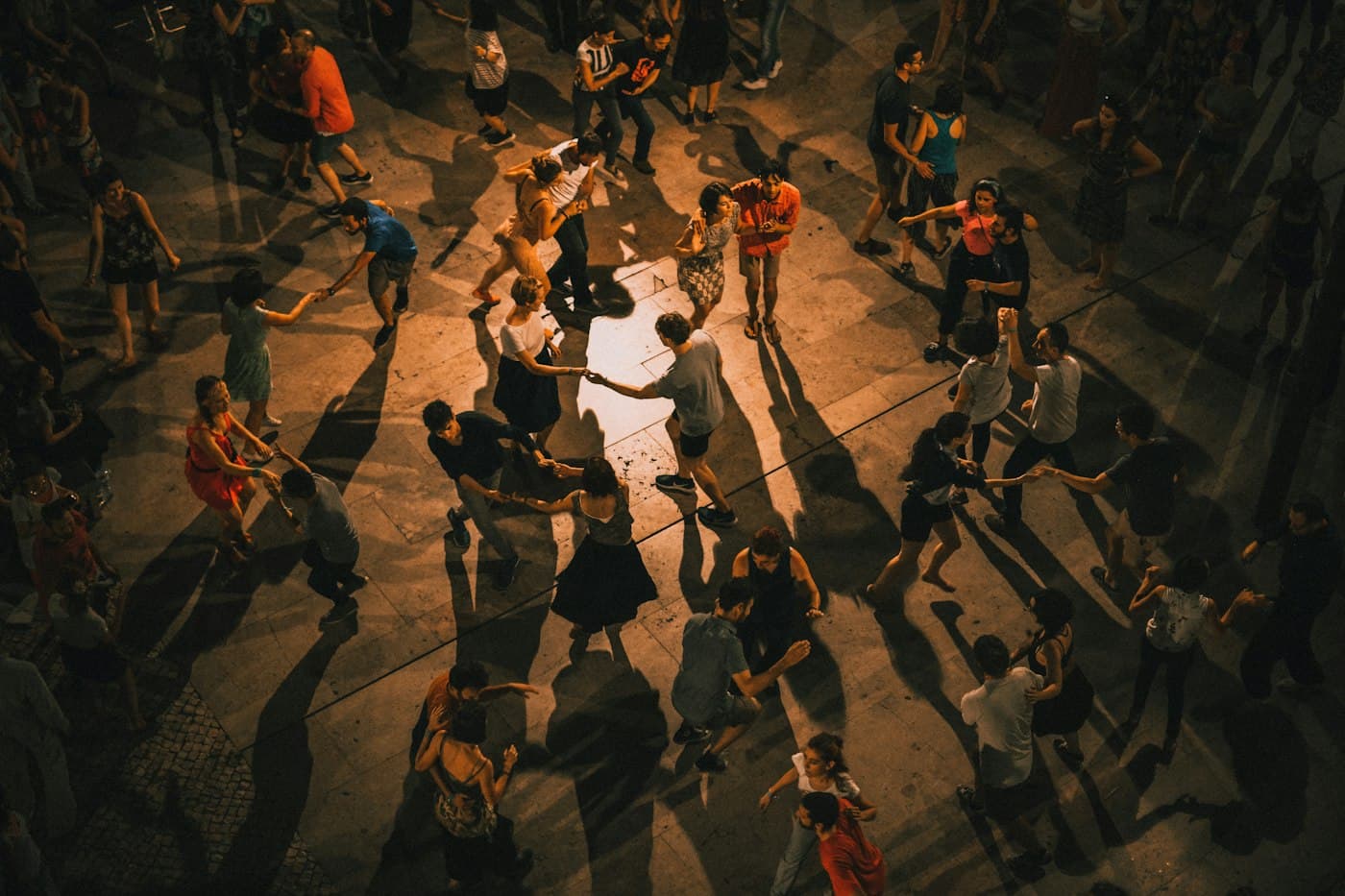 People dancing together in a city square at night
